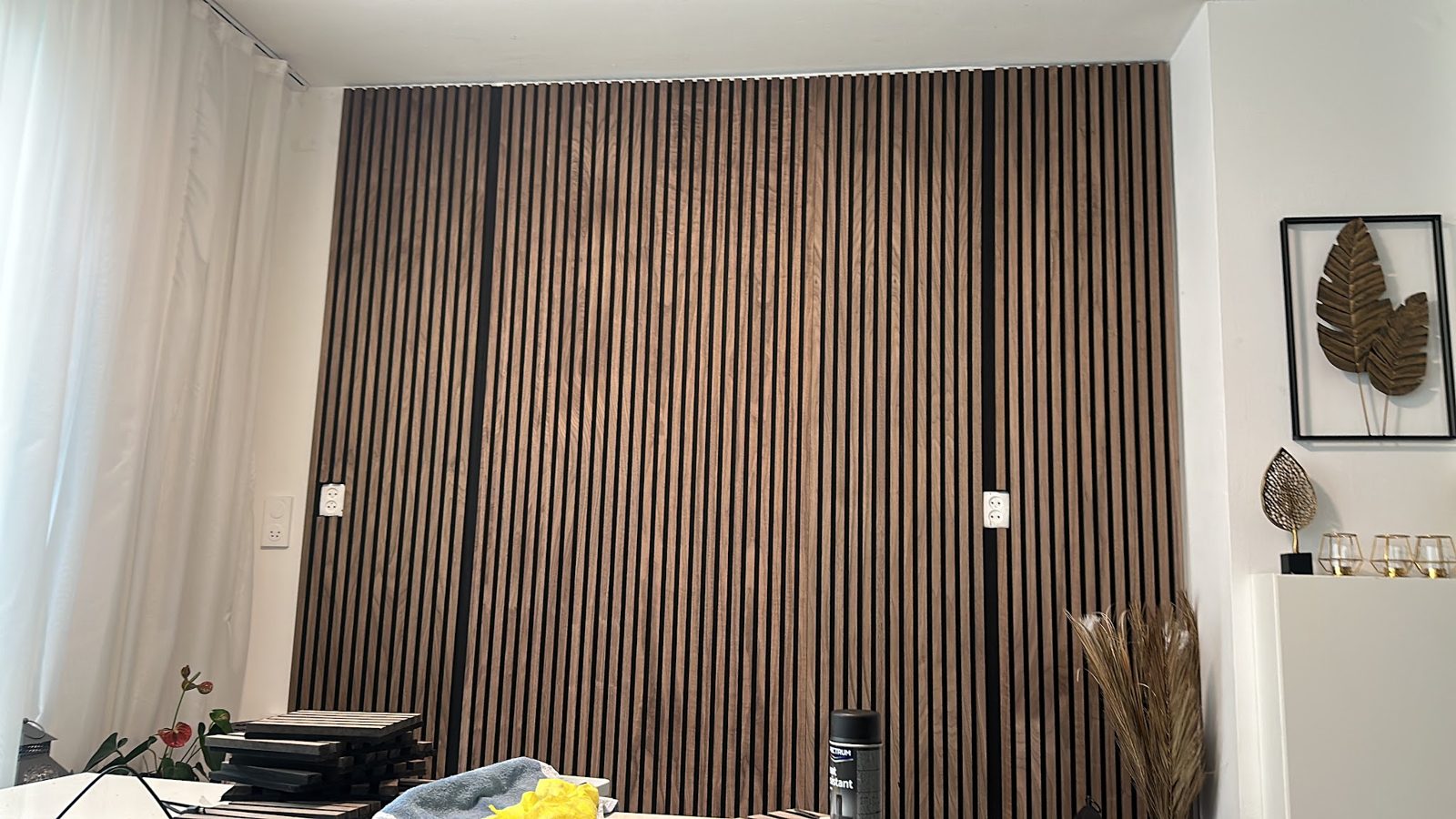 Afgewerkte woonkamer met houten lamellenwand