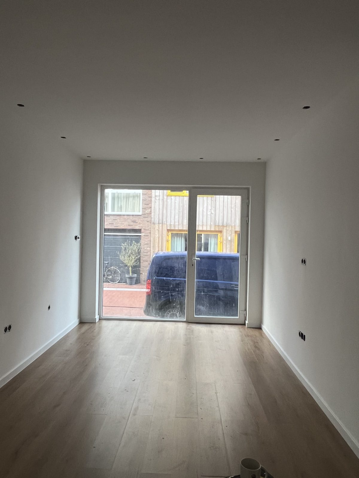 Afgewerkte kamer met nieuwe vloer en schuifpui